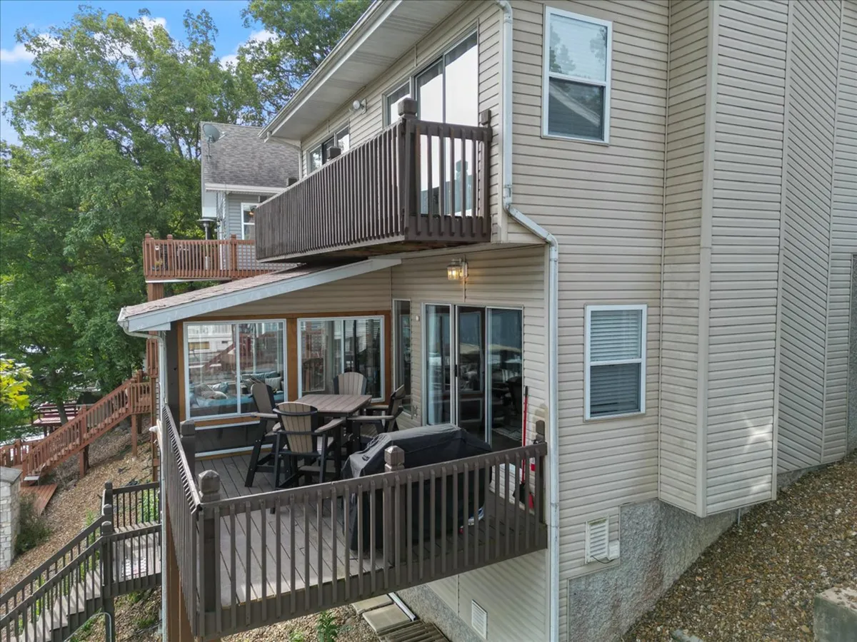 An exterior shot featuring a balcony with comfortable seating, a grill, and large windows overlooking the outdoor area. The atmosphere is casual and welcoming, perfect for gathering with friends before heading out for the evening or winding down after enjoying local nightlife.