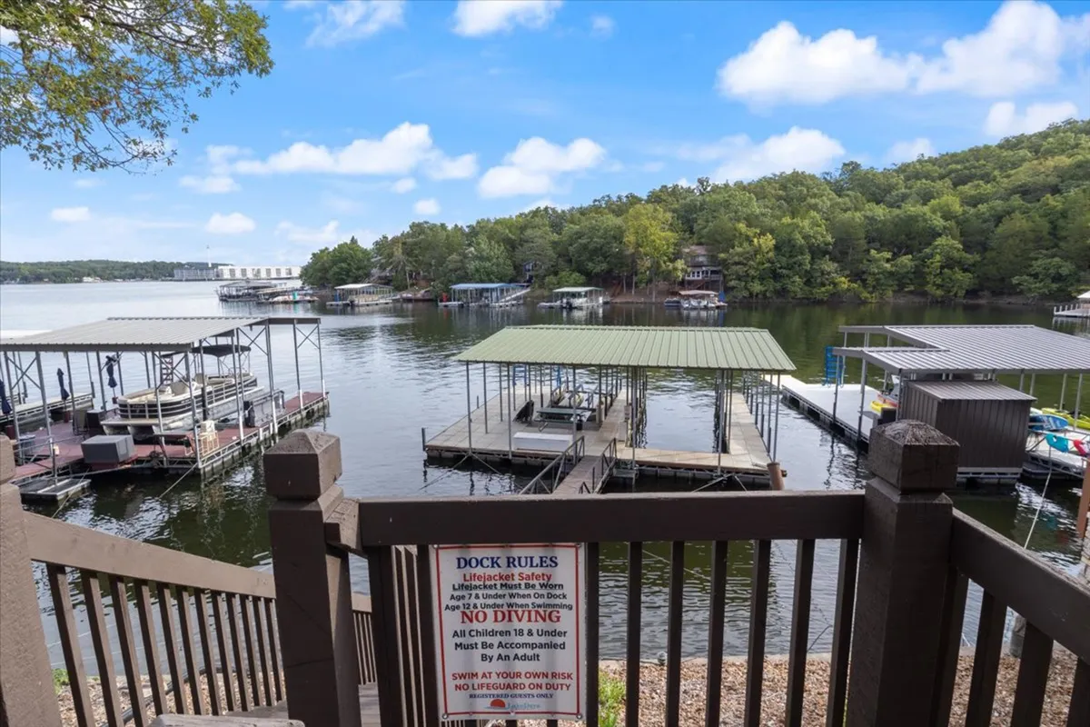 A tranquil scene showing a dock stretching out over the water, with boats moored nearby and lush trees providing a picturesque backdrop. The image suggests opportunities for swimming, boating, and fishing, all central to the lake life experience described in the section.