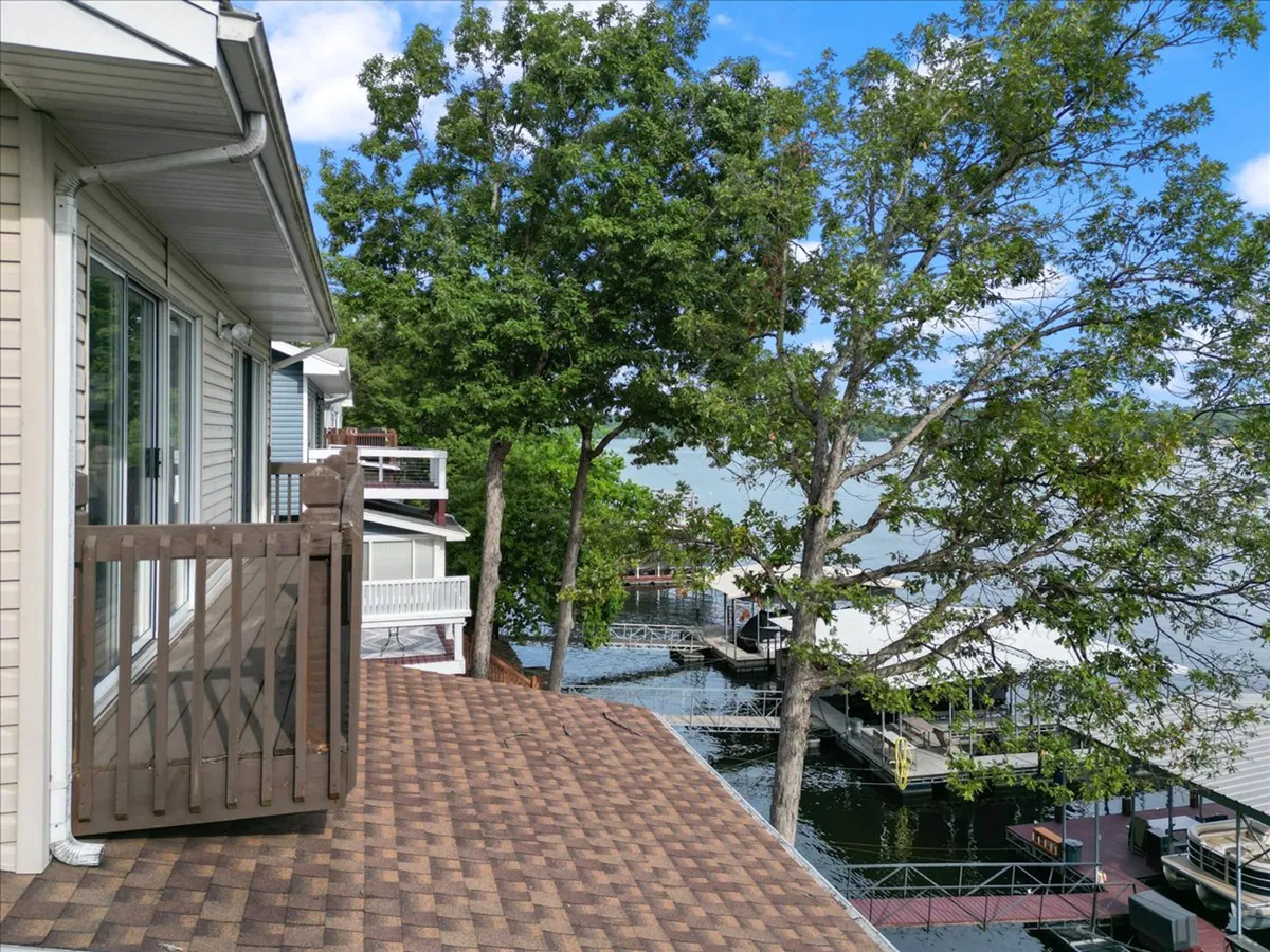 A tranquil balcony view overlooks the water, with a sturdy railing and natural surroundings. The scene highlights outdoor relaxation spaces that are both enjoyable and safe for families and groups.