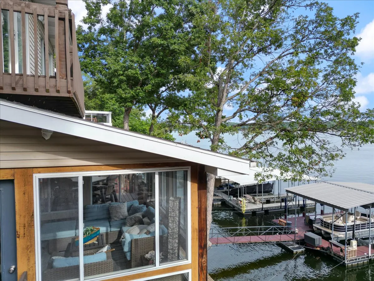 This exterior image showcases a dock extending into the lake, surrounded by trees and an inviting outdoor seating area. The setting suggests opportunities for boating, fishing, and relaxing by the water—reflecting the vibrant lakefront atmosphere and proximity to local attractions.